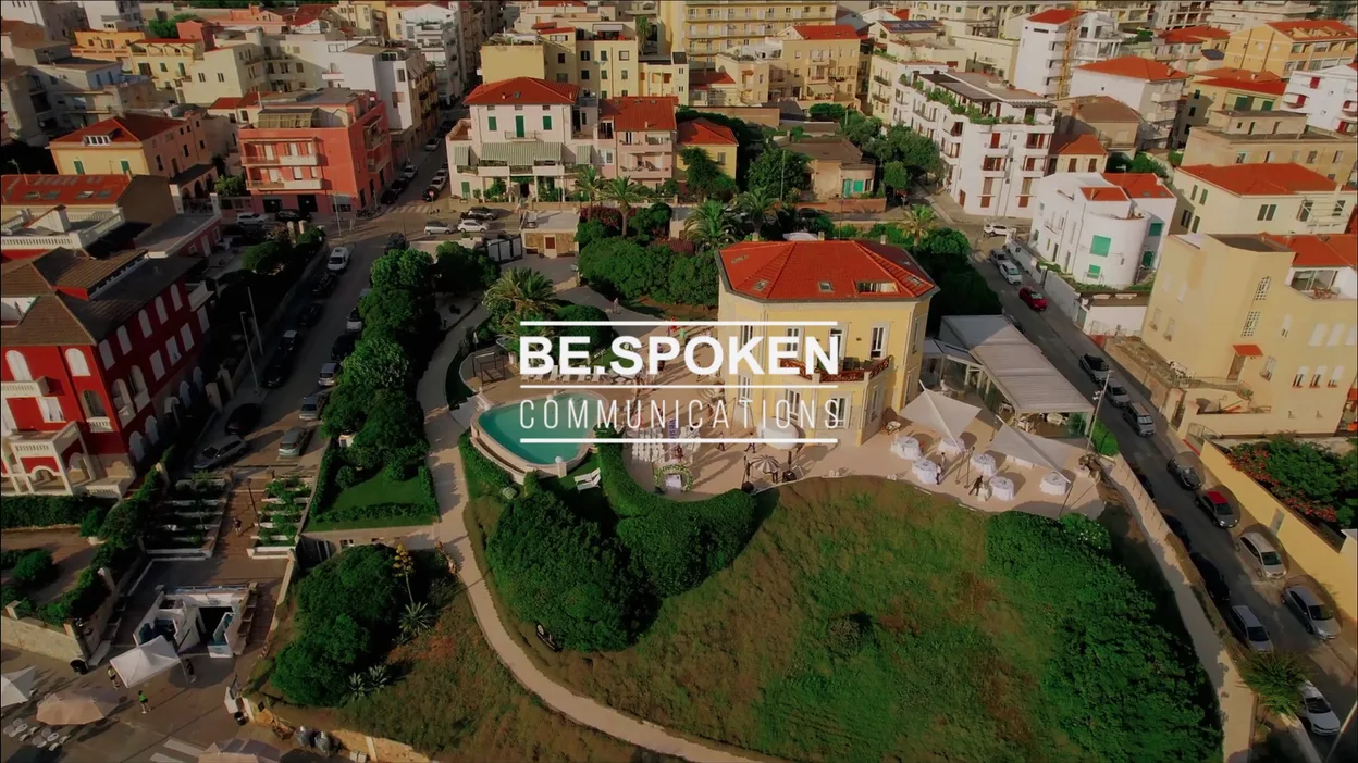 Be.Spoken Communications logo over an aerial view of a seaside town